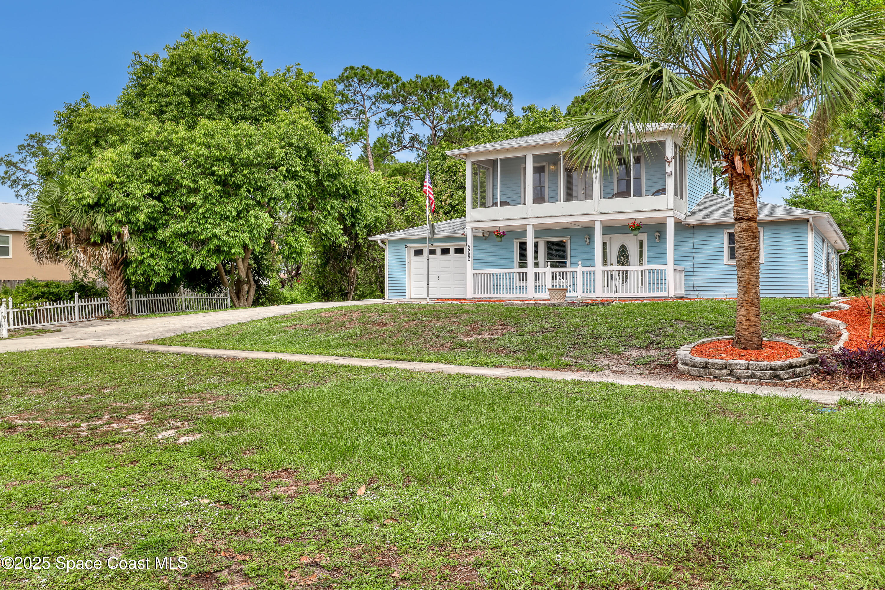 5280 Curtis Boulevard Cocoa, FL 32927 - Photo 7 of 45 a view of a house with a big yard and palm trees