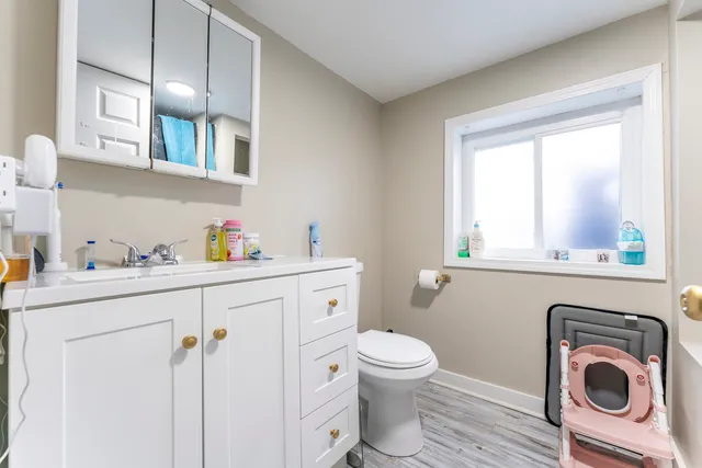 a bathroom with a sink a toilet and a window