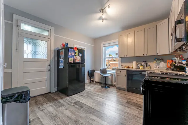 a kitchen with a refrigerator and a stove top oven