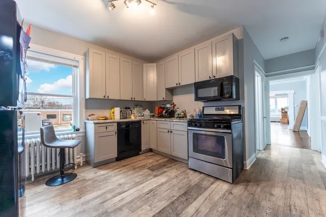a kitchen with granite countertop a sink cabinets and stainless steel appliances