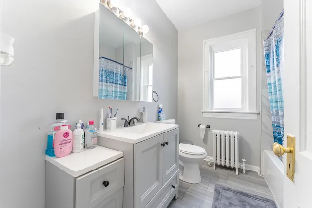a bathroom with a sink toilet vanity and tub
