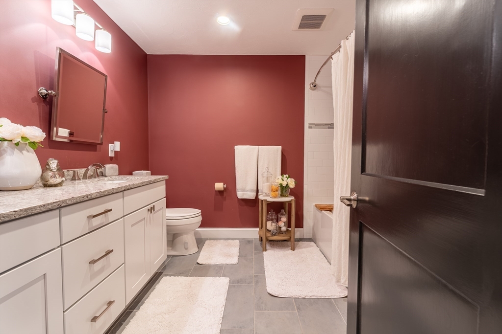 38 Cherry Street, Unit B Hudson, MA 01749 - Photo 31 of 33 a bathroom with a double vanity sink toilet and mirror