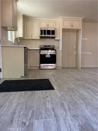 a kitchen with granite countertop a stove top oven a sink and cabinets
