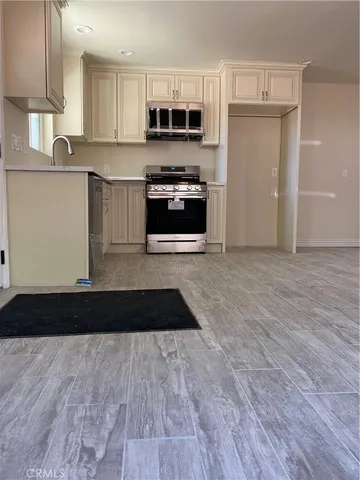 a kitchen with granite countertop a stove top oven a sink and cabinets