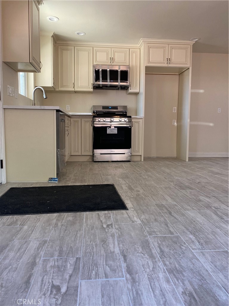 a kitchen with granite countertop a stove top oven a sink and cabinets