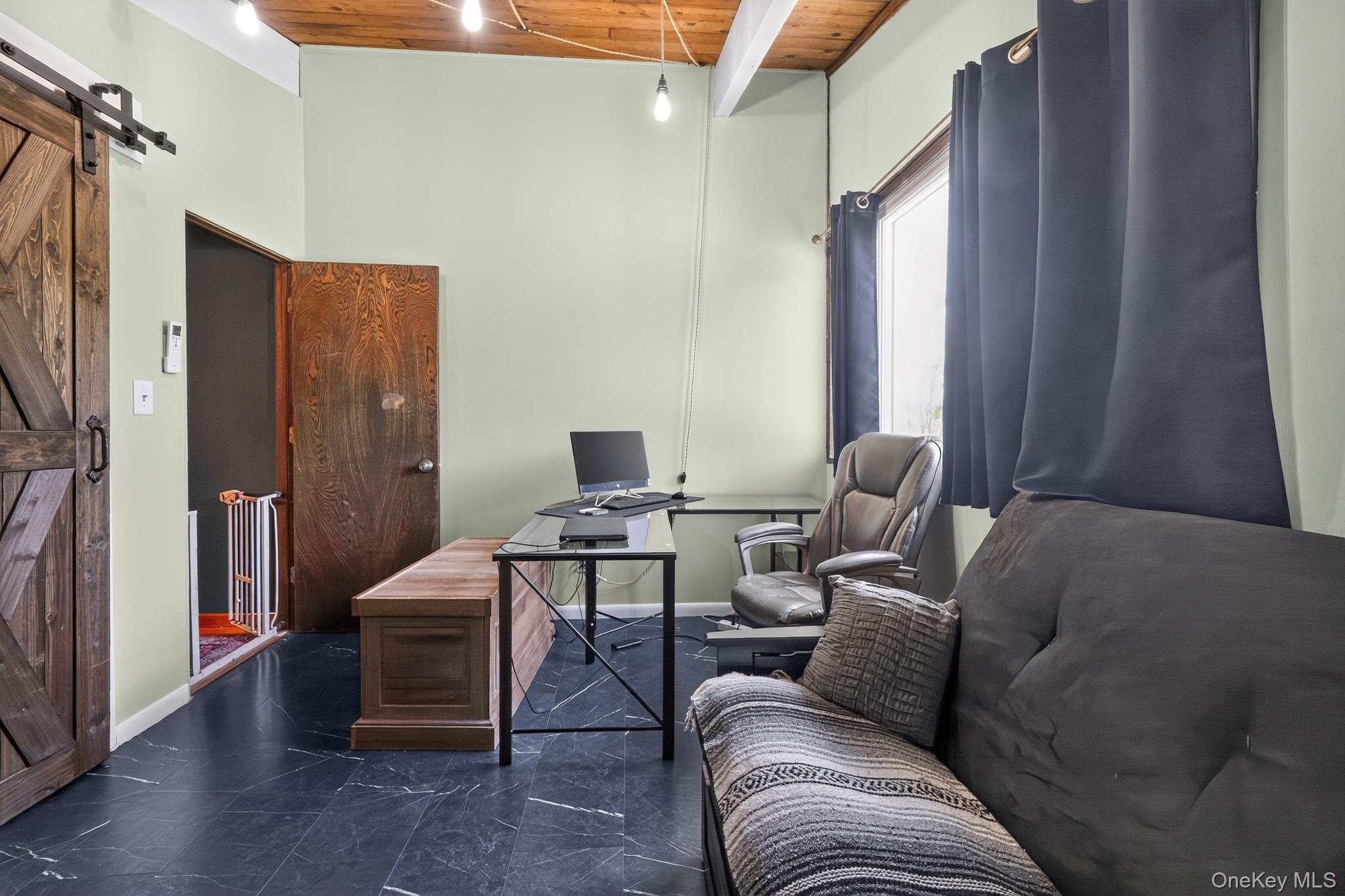 424 Laroe Road Chester, NY 10918 - Photo 39 of 43 Spacious room featuring vaulted ceilings with exposed wood beams, dark wood-finish flooring, and a barn door entry