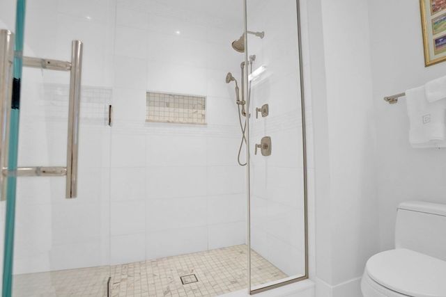 a bathroom with a shower a toilet and a sink