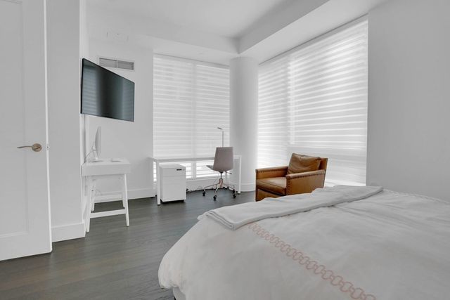 a bedroom with a bed and a flat tv screen