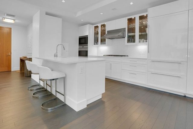 a kitchen with stainless steel appliances granite countertop a sink and a stove top oven