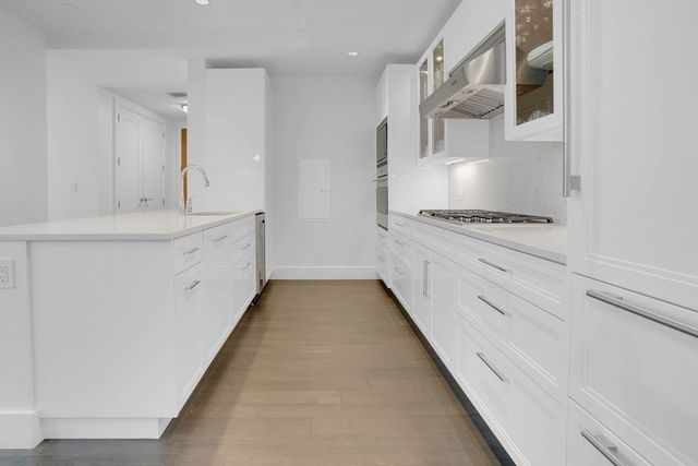 a kitchen with granite countertop white cabinets and white appliances