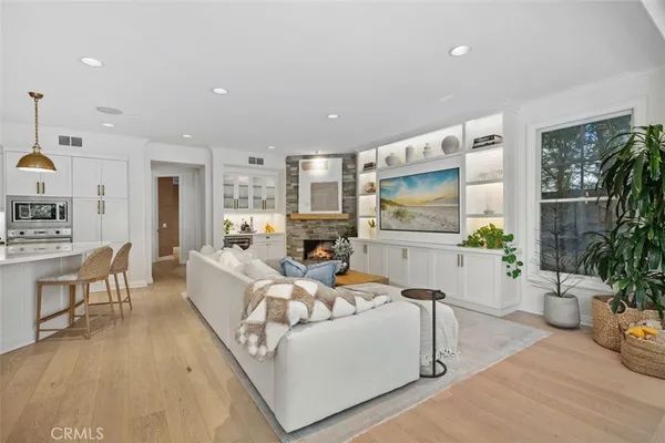 a living room with furniture kitchen view and a large window