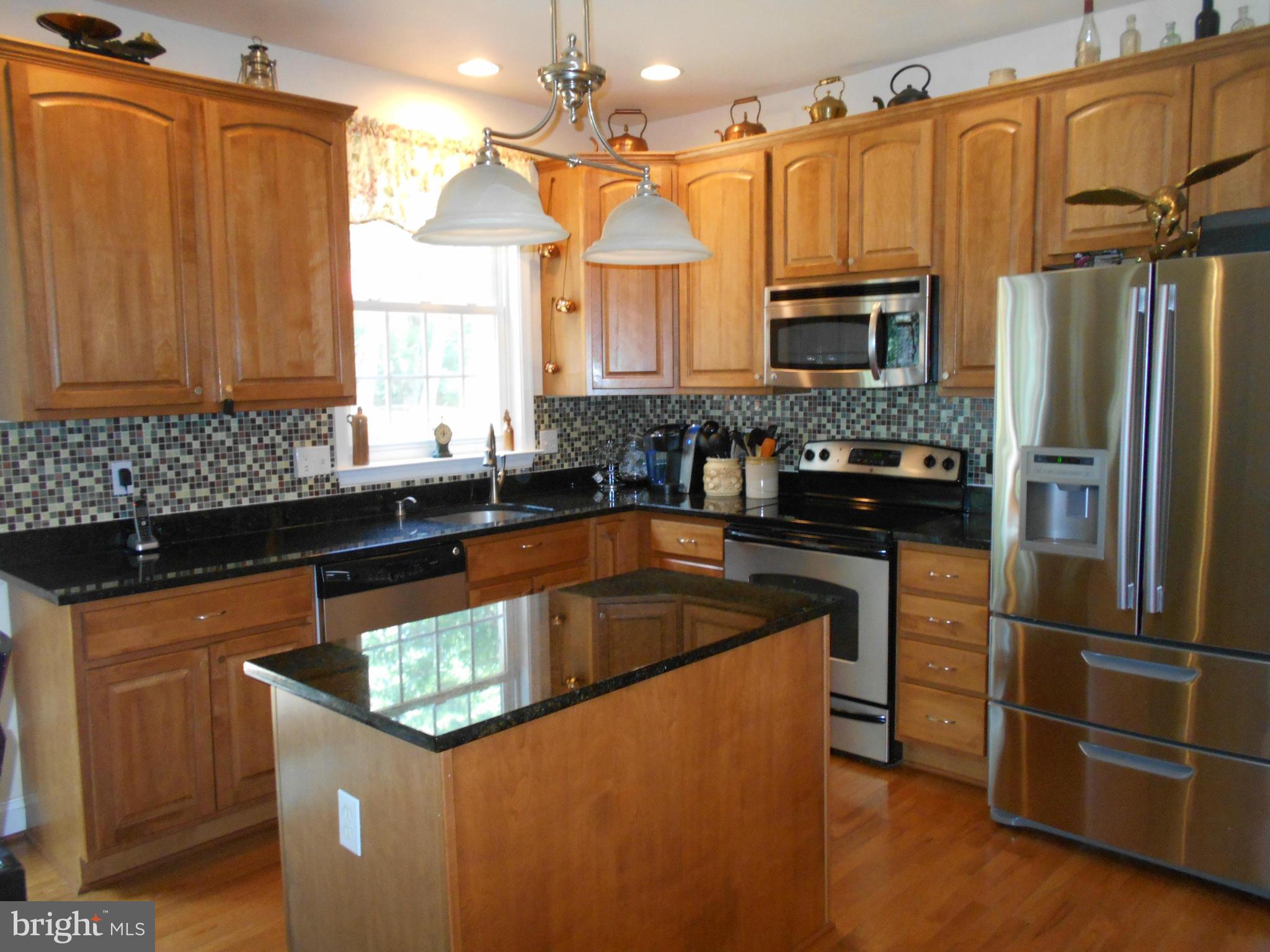 7726 Locust Wood Road Severn, MD 21144 - Photo 3 of 23 a kitchen with granite countertop a sink dishwasher stove and refrigerator with wooden floor