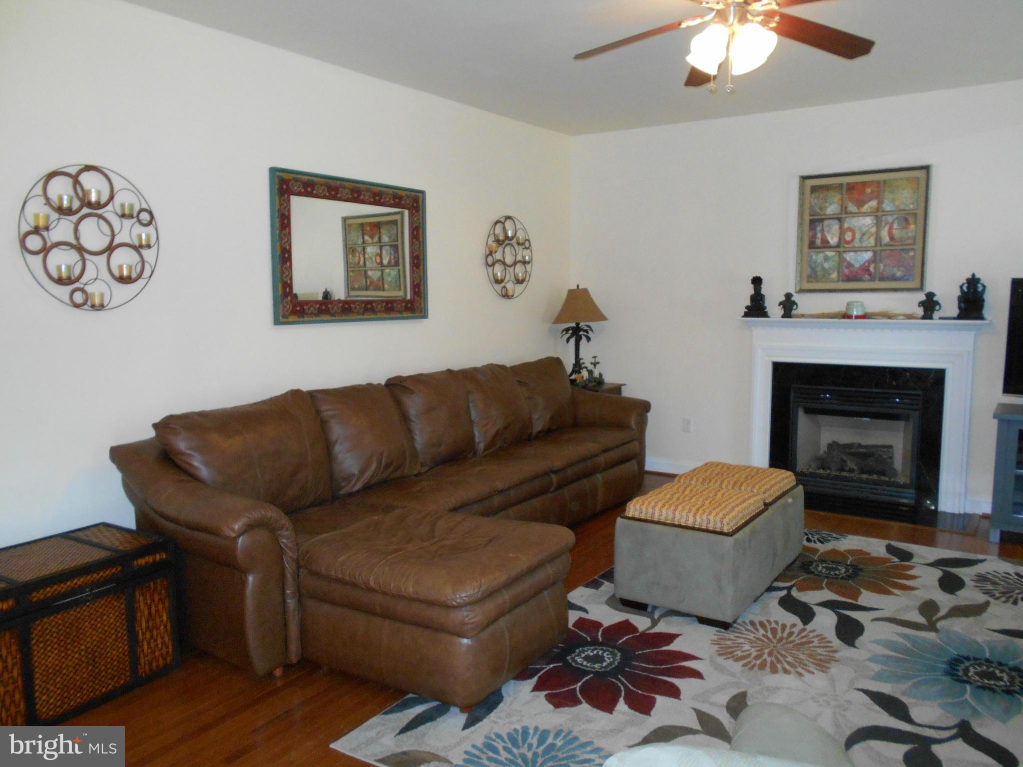 7726 Locust Wood Road Severn, MD 21144 - Photo 5 of 23 a living room with furniture a couch and a fireplace