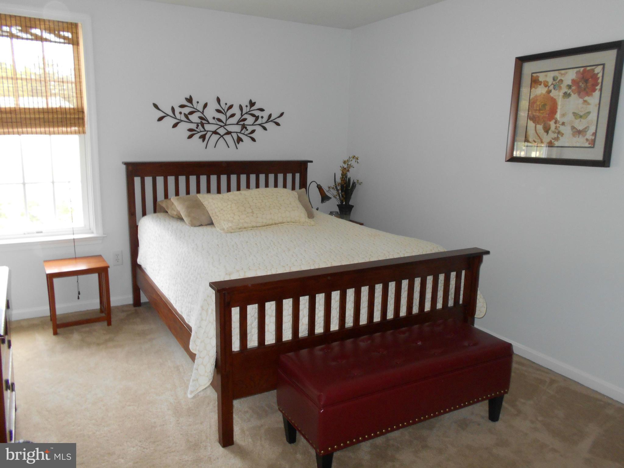 7726 Locust Wood Road Severn, MD 21144 - Photo 9 of 23 a bed sitting in a bedroom next to a window