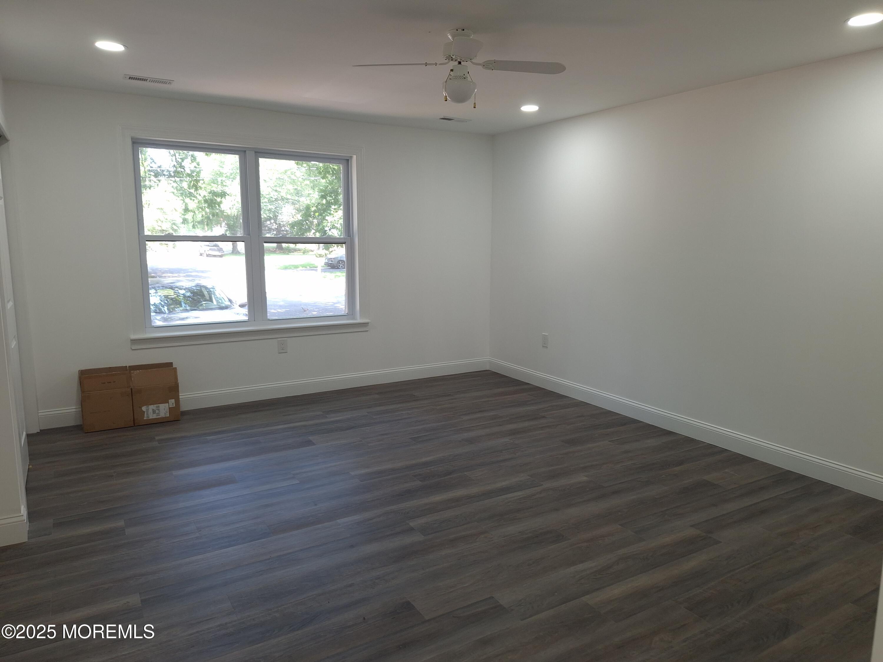 414 Oak Tree Road Freehold, NJ 07728 - Photo 15 of 25 an empty room with wooden floor and windows
