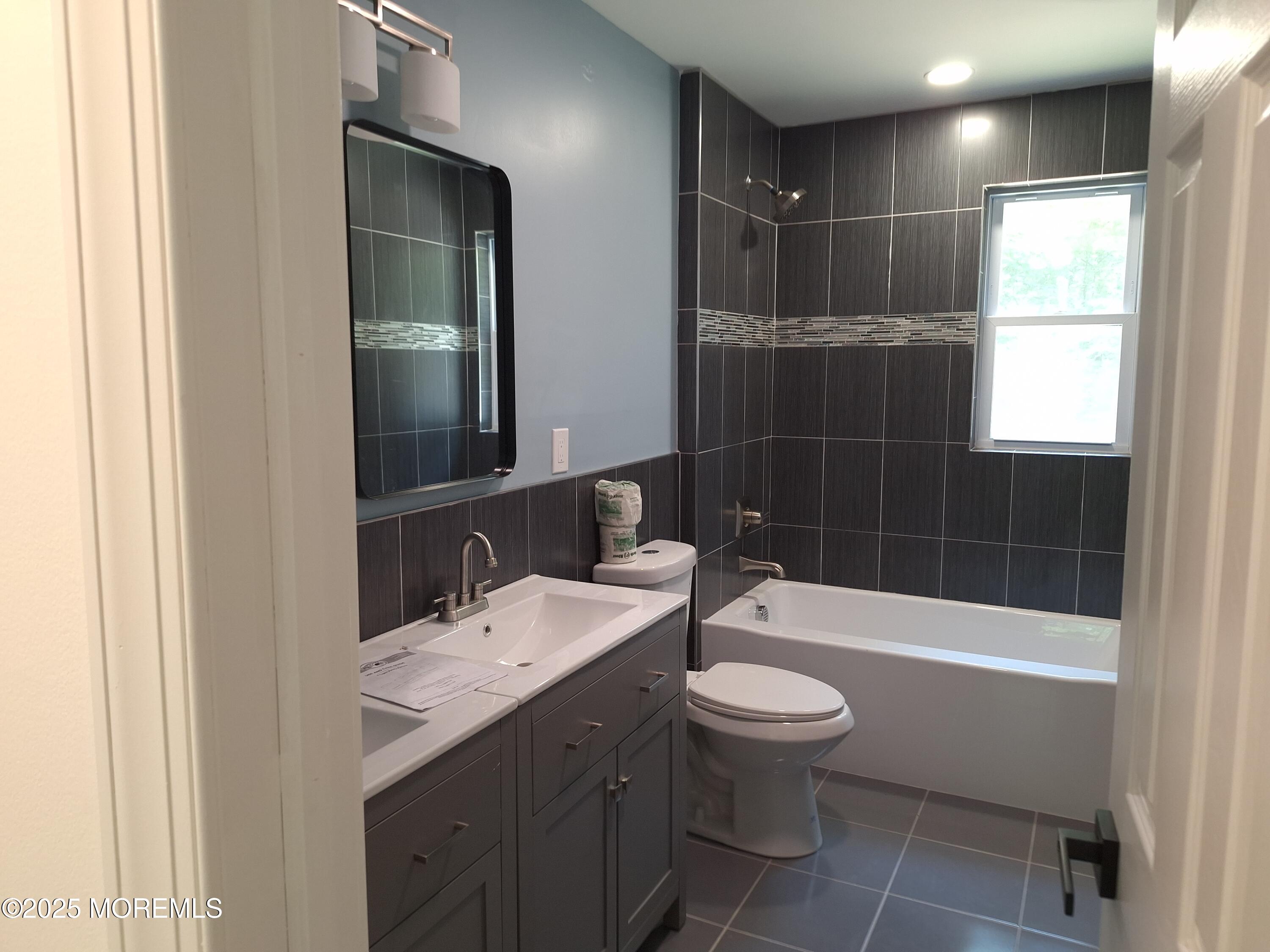 414 Oak Tree Road Freehold, NJ 07728 - Photo 18 of 25 a bathroom with a bathtub shower sink mirror and toilet