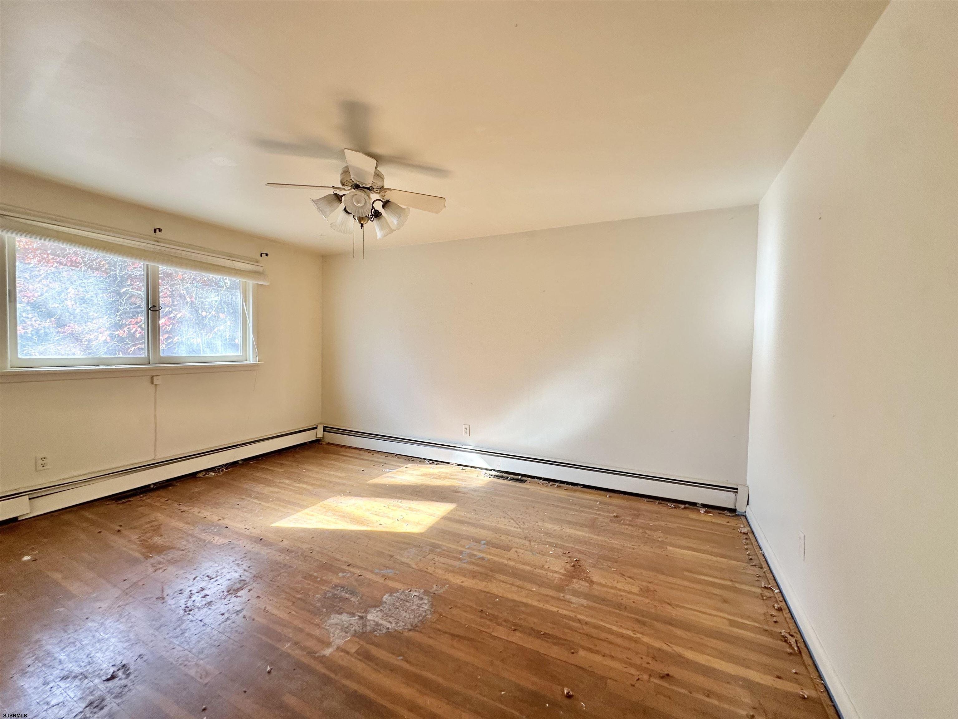 928 Traymore Parkway Absecon, NJ 08201 - Photo 12 of 25 wooden floor in an empty room with a window