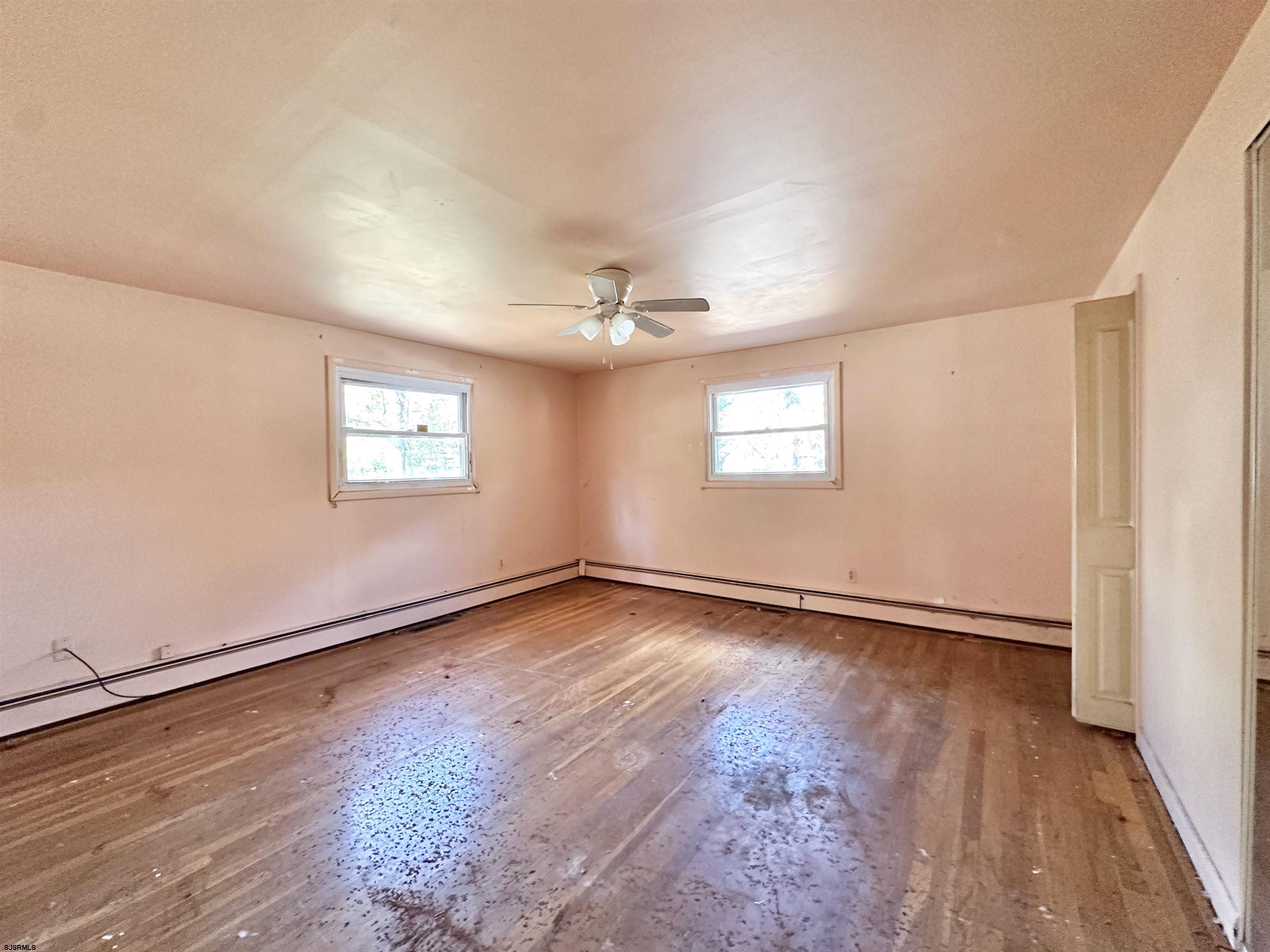 928 Traymore Parkway Absecon, NJ 08201 - Photo 13 of 25 an empty room with wooden floor and windows