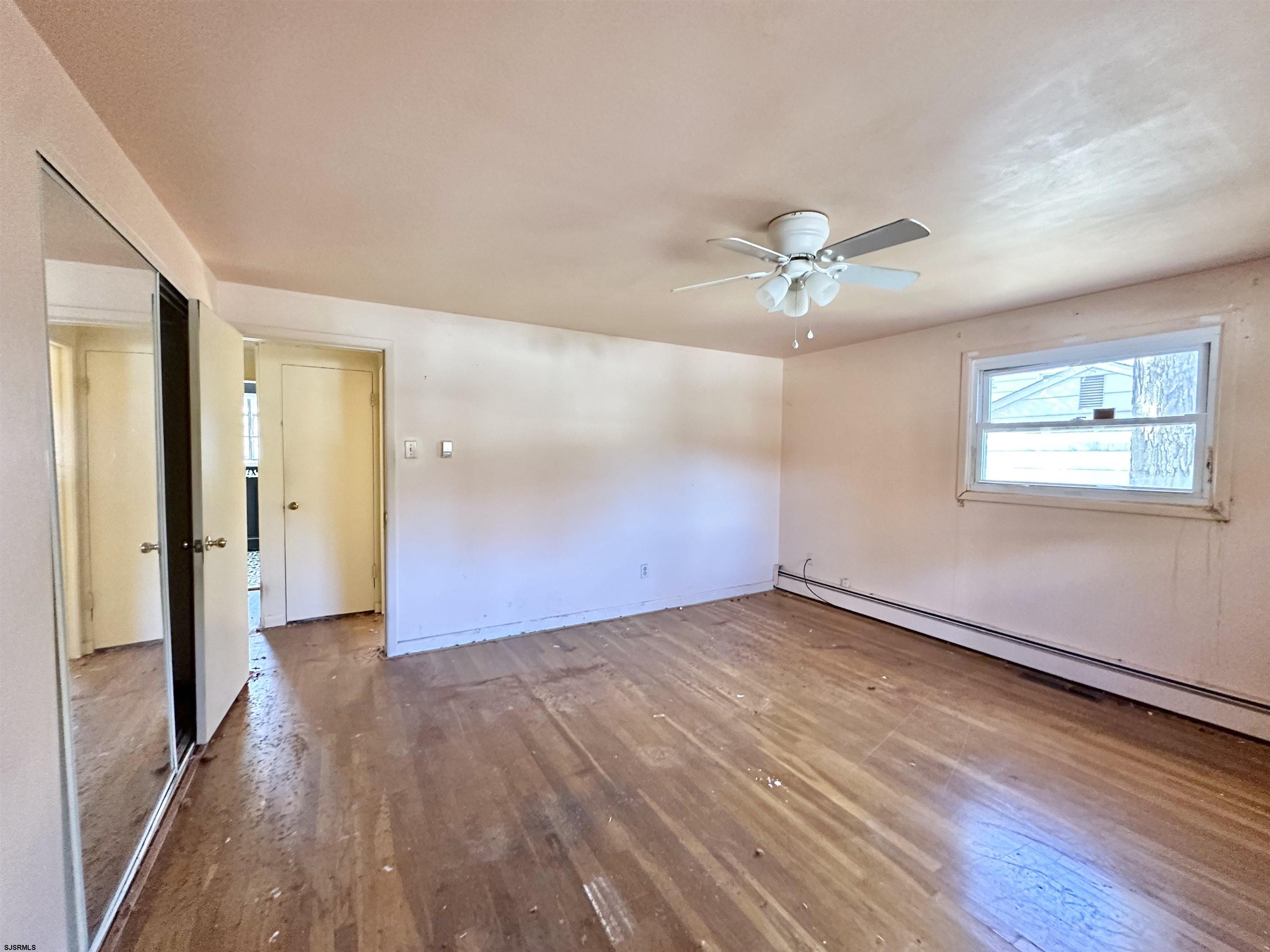 928 Traymore Parkway Absecon, NJ 08201 - Photo 14 of 25 wooden floor in an empty room with a window