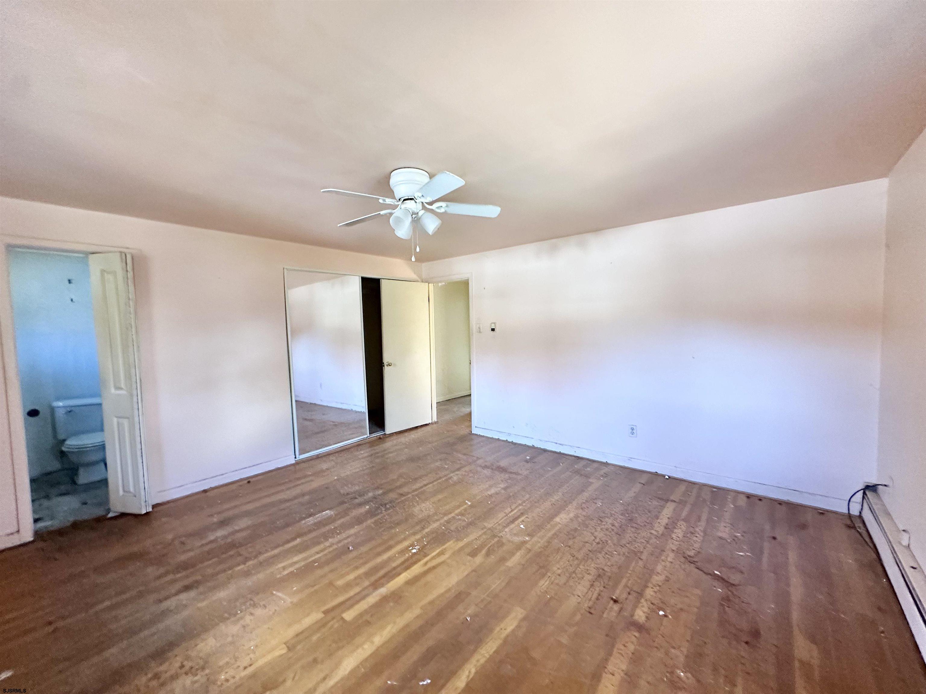 928 Traymore Parkway Absecon, NJ 08201 - Photo 15 of 25 an empty room with wooden floor and chandelier fan