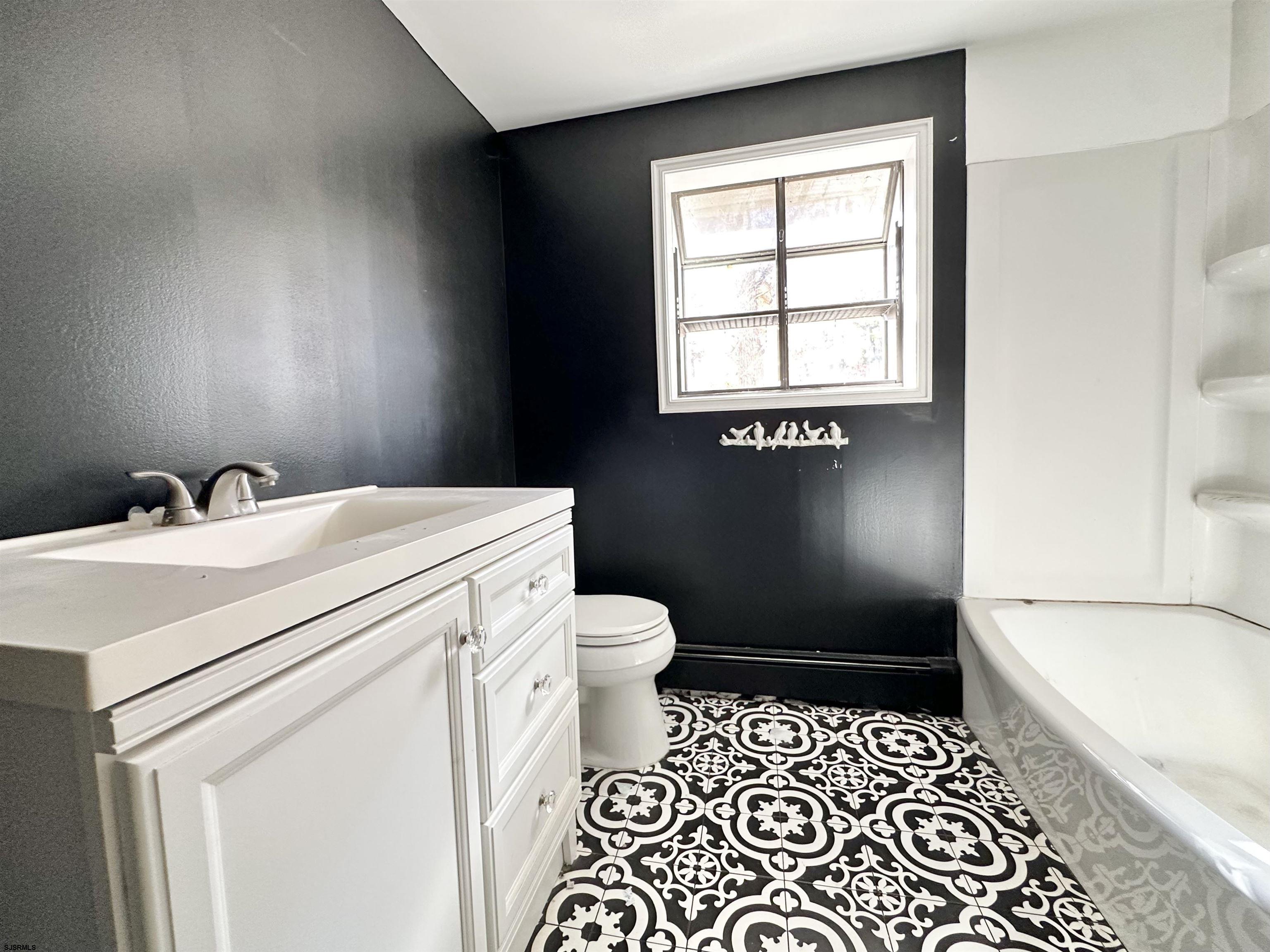 928 Traymore Parkway Absecon, NJ 08201 - Photo 16 of 25 a bathroom with a sink a toilet and window