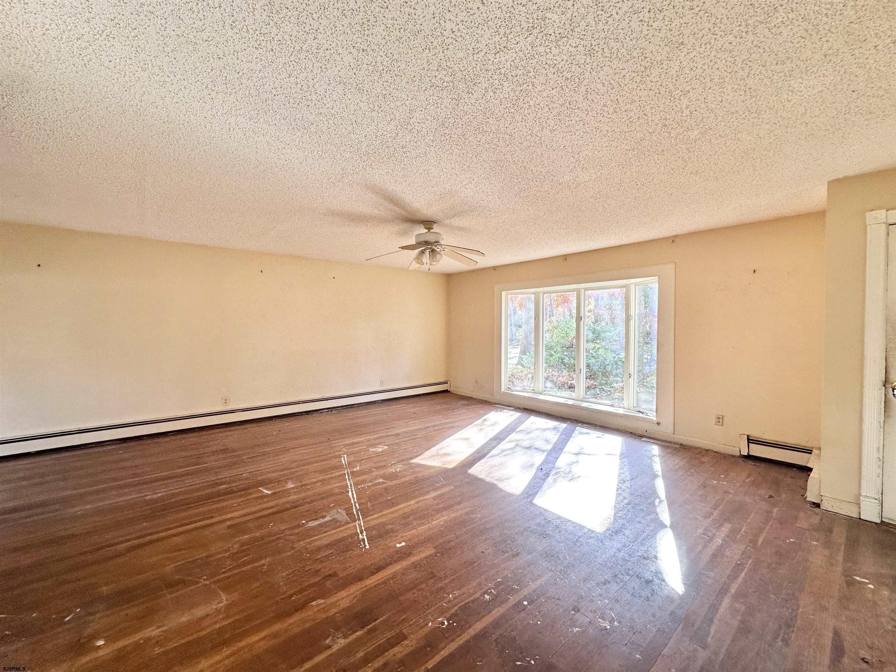 928 Traymore Parkway Absecon, NJ 08201 - Photo 9 of 25 an empty room with wooden floor and windows