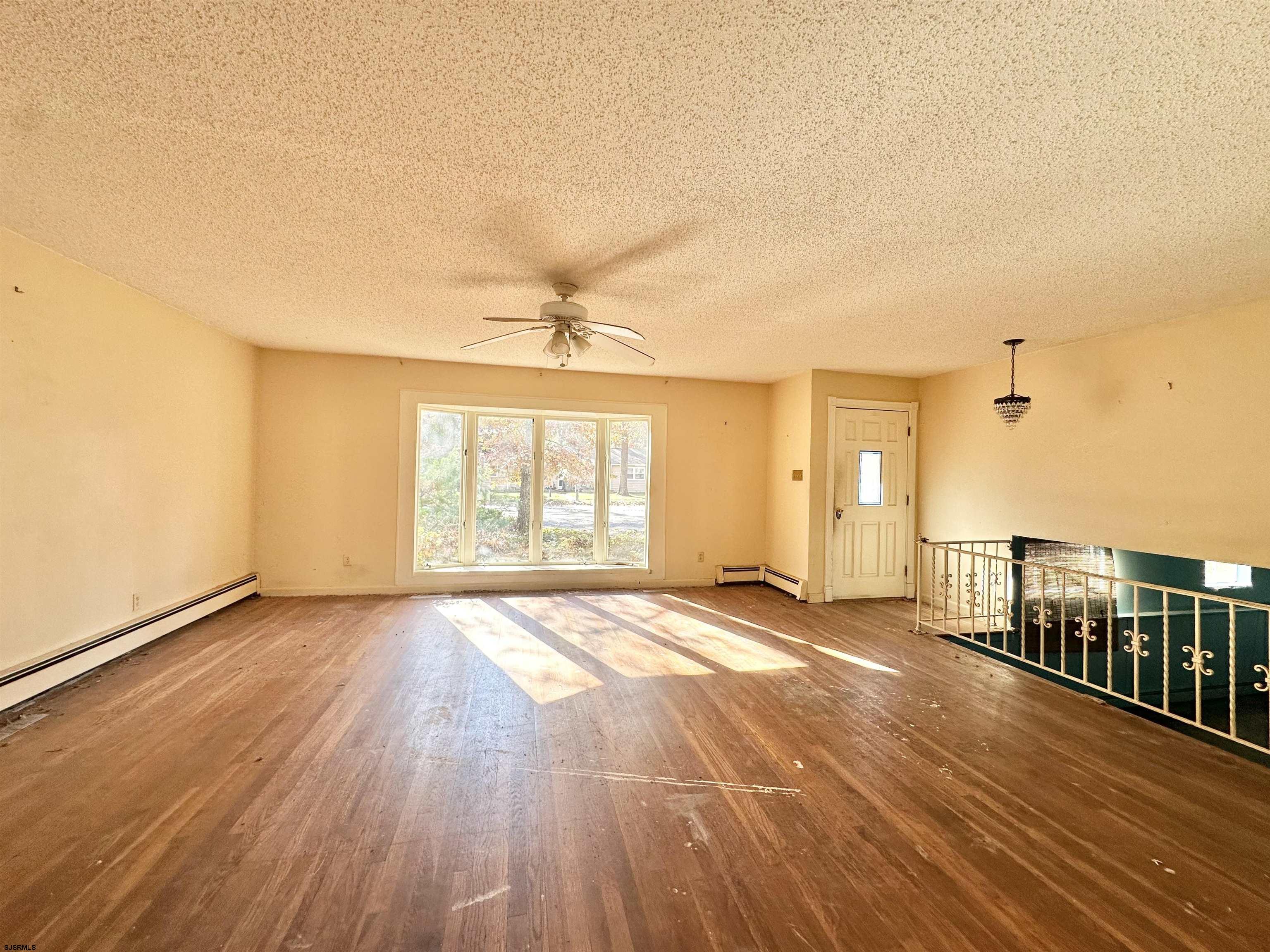 928 Traymore Parkway Absecon, NJ 08201 - Photo 10 of 25 an empty room with wooden floor and windows
