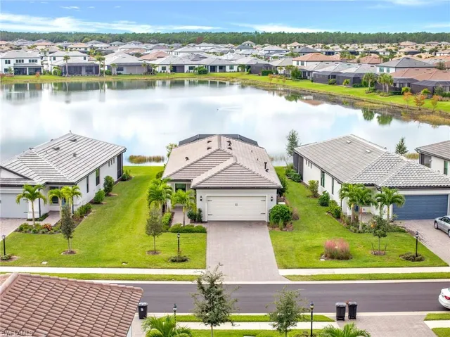 an aerial view of residential houses with outdoor space and lake view