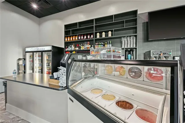 a kitchen with stainless steel appliances kitchen island granite countertop a refrigerator a stove and a dining table