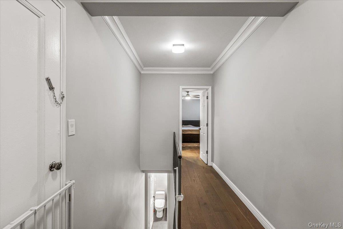 99-40 63rd Road, Unit 1Z Queens, NY 11374 - Photo 13 of 25 Hallway with dark wood-type flooring, crown molding, an upstairs landing, and baseboards