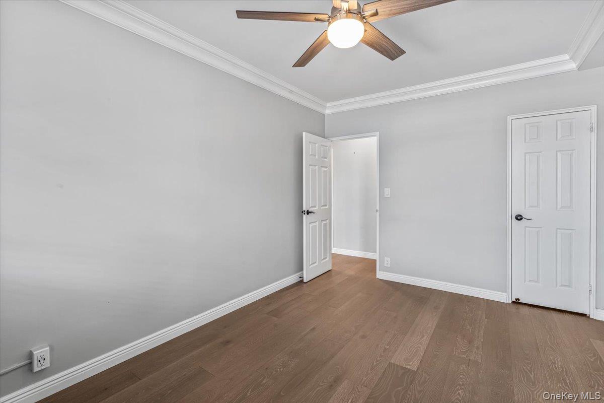 99-40 63rd Road, Unit 1Z Queens, NY 11374 - Photo 16 of 25 Empty room featuring ceiling fan, ornamental molding, wood finished floors, and baseboards