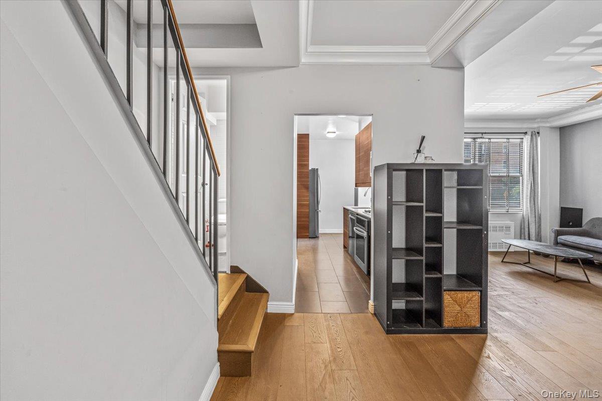 99-40 63rd Road, Unit 1Z Queens, NY 11374 - Photo 3 of 25 Foyer entrance featuring light wood finished floors, stairs, baseboards, ceiling fan, and a tray ceiling