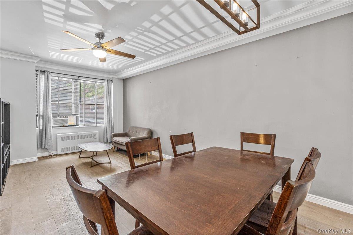 99-40 63rd Road, Unit 1Z Queens, NY 11374 - Photo 5 of 25 Dining room featuring radiator, ornamental molding, ceiling fan, light wood-style floors, and baseboards
