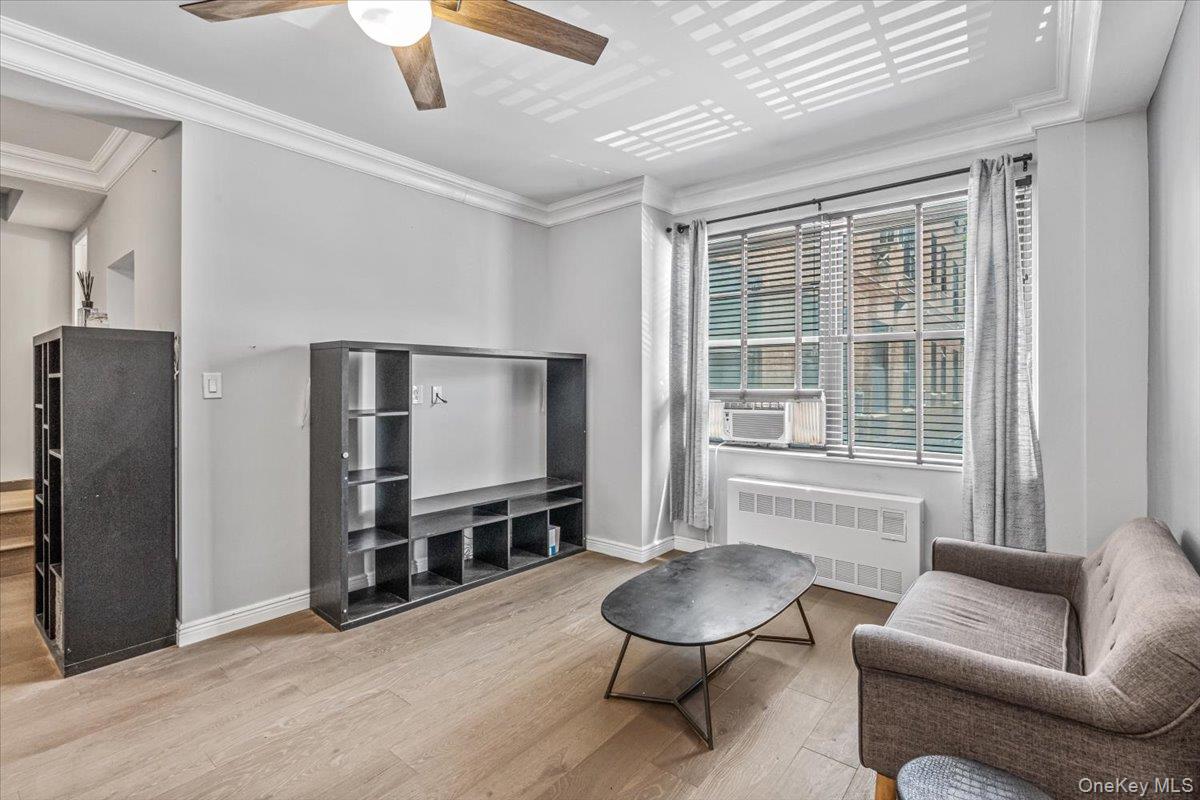 99-40 63rd Road, Unit 1Z Queens, NY 11374 - Photo 7 of 25 Sitting room featuring radiator heating unit, wood finished floors, baseboards, ceiling fan, and crown molding