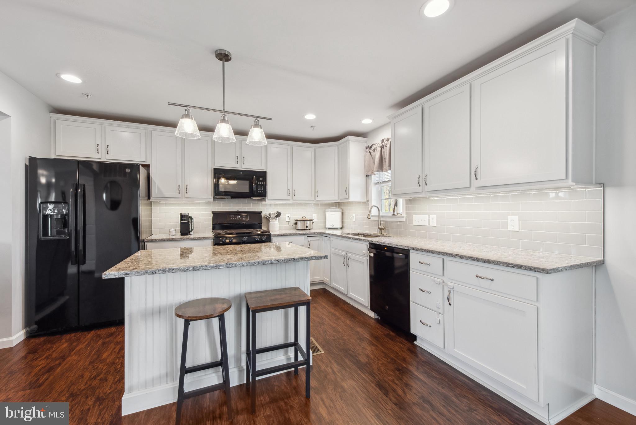 910 Rosedale Avenue Rosedale, MD 21237 - Photo 8 of 41 a kitchen with a center island white cabinets and stainless steel appliances