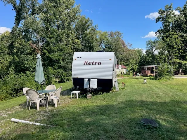 a kitchen with stainless steel appliances granite countertop a refrigerator a sink dishwasher a stove and a dining table with wooden floor