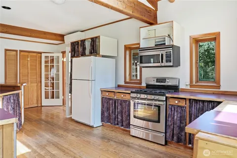 a kitchen with stainless steel appliances granite countertop a refrigerator a stove a sink and a microwave