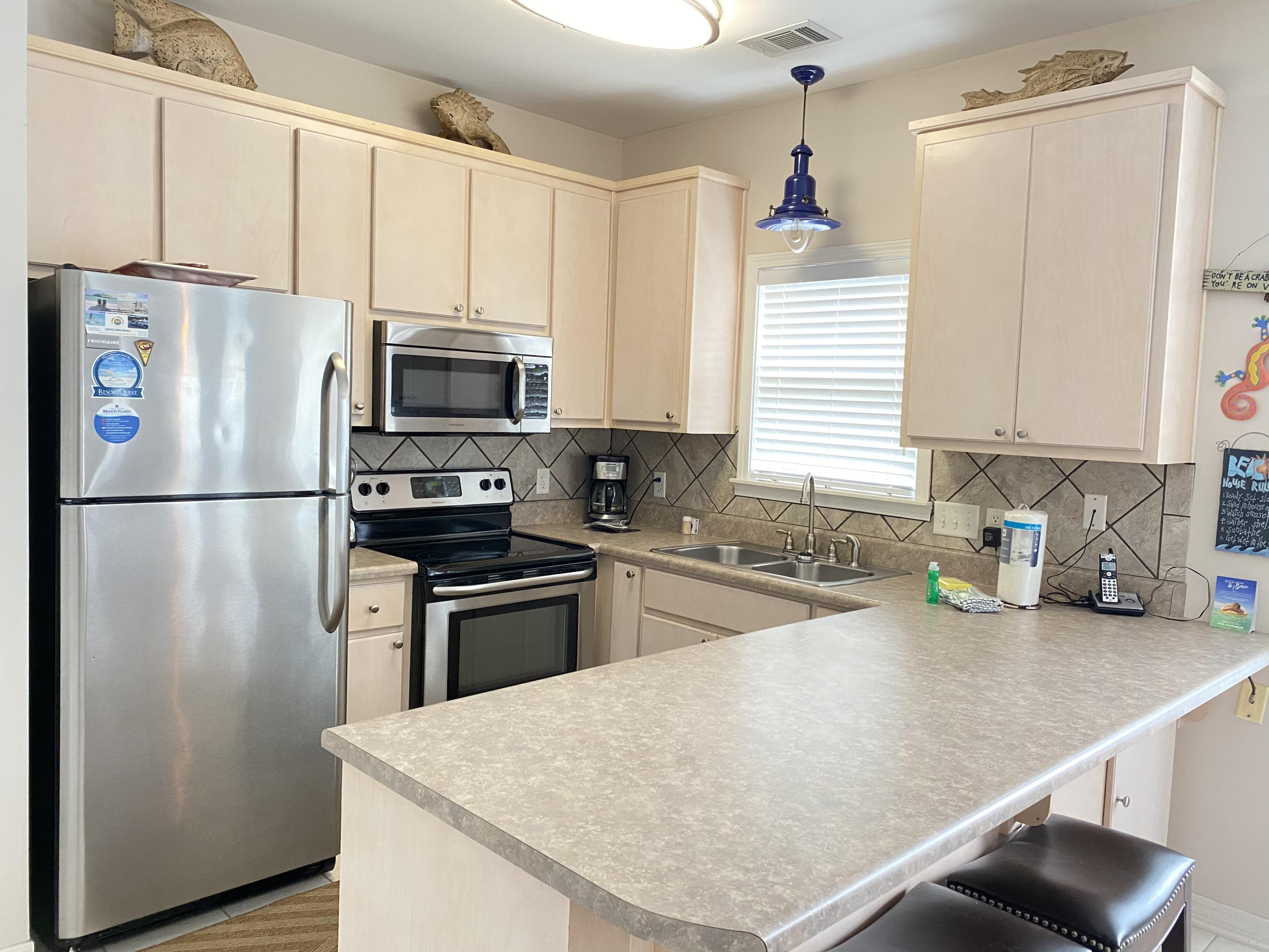57 Emerald Dunes Circle Santa Rosa Beach, FL 32459 - Photo 7 of 26 a kitchen with stainless steel appliances a refrigerator sink and microwave