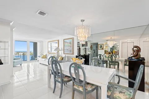 a view of a dining room and livingroom with furniture wooden floor a rug a fireplace and windows