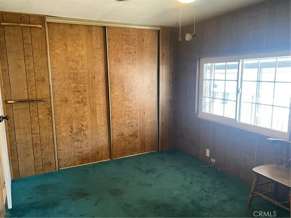 a view of an empty room with window and hardwood