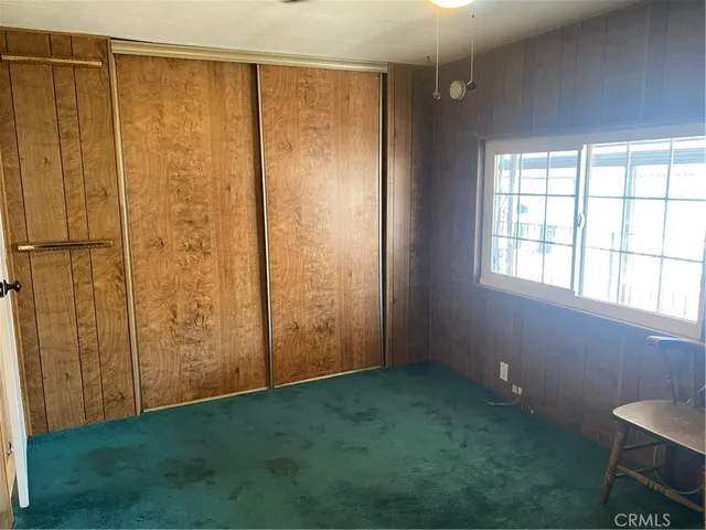 a view of an empty room with window and hardwood