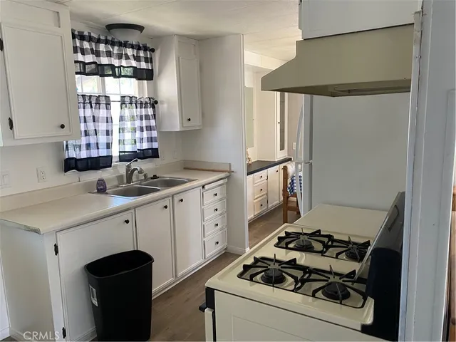 a kitchen with a stove cabinets and a window