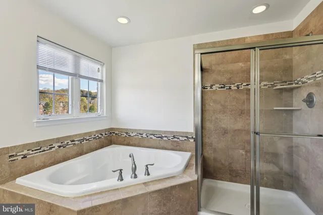 a bathroom with a tub sink and mirror