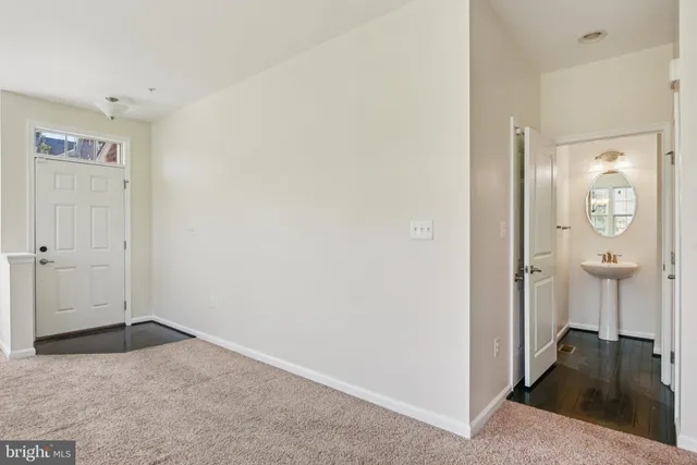 a view of a livingroom with wooden floor and a bathroom