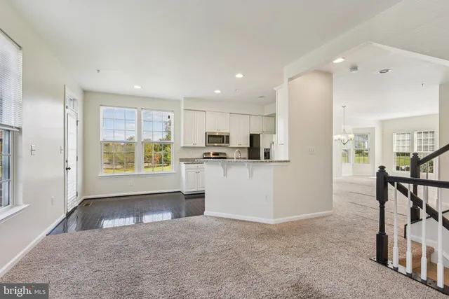 a view of kitchen with refrigerator and wooden floor