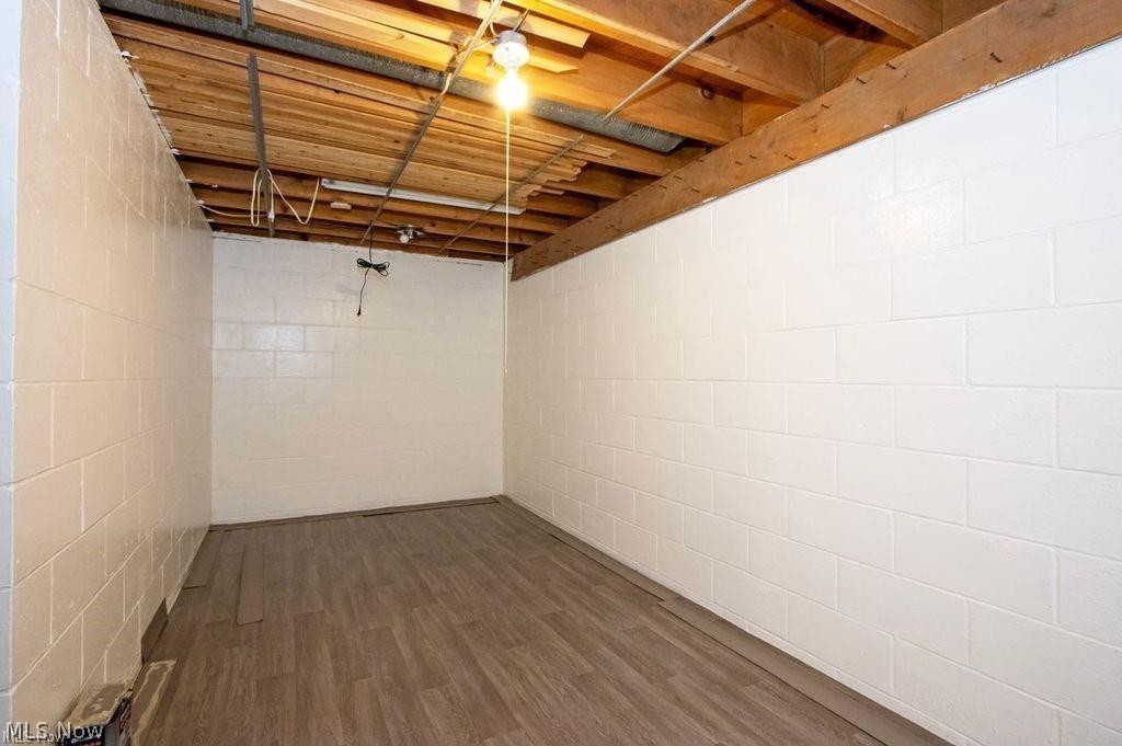 2530 Tuckahoe Road Wooster, OH 44691 - Photo 27 of 29 Lower level space featuring painted cinder block walls, exposed wood ceiling joists, and wood-finish flooring
