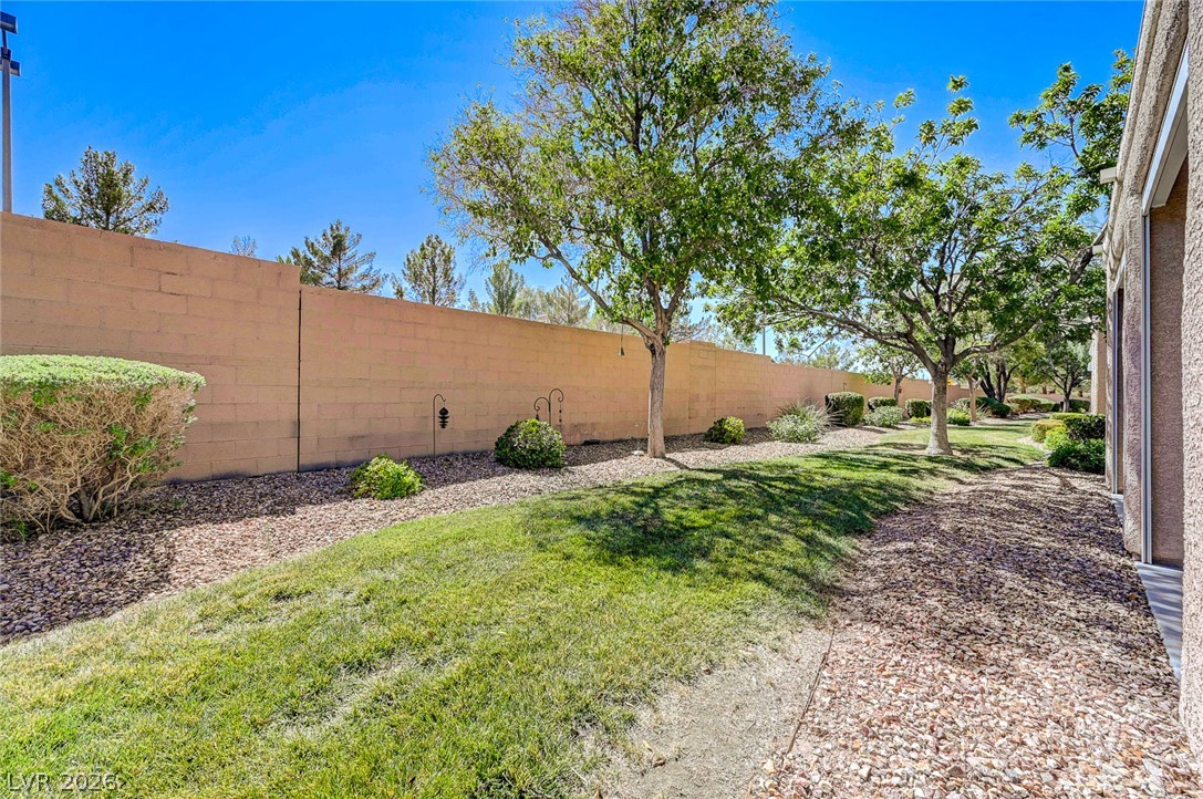 2529 Springville Way Henderson, NV 89052 - Photo 57 of 70 Mature trees shade the grassy yard bordered by a tall privacy wall.