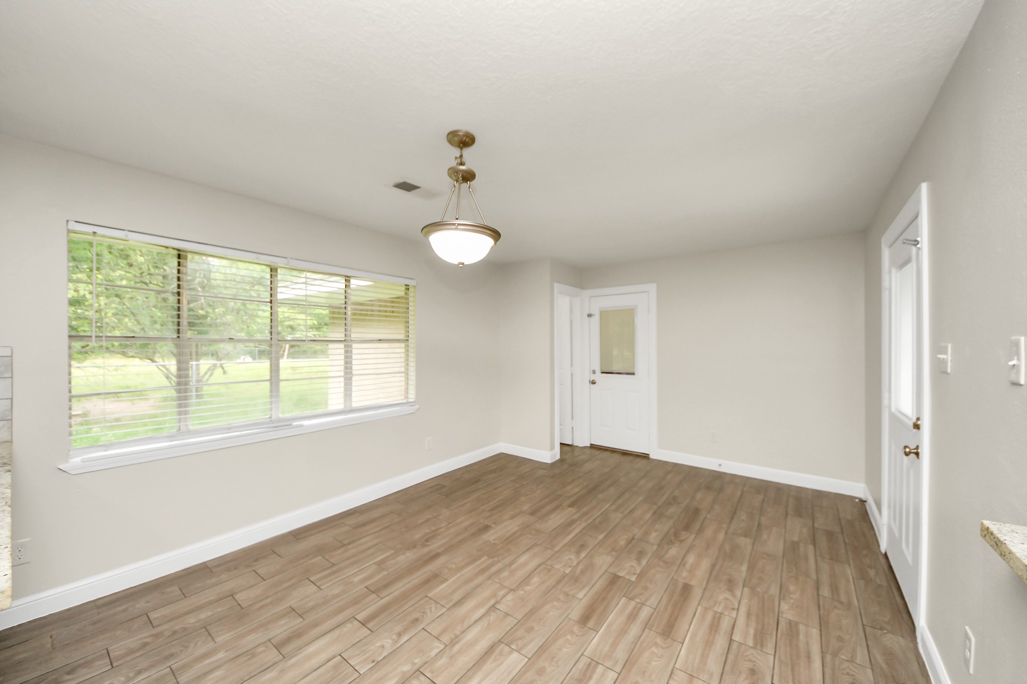 19435 Interstate 45 Spring, TX 77388 - Photo 13 of 24 a view of an empty room with wooden floor and a window