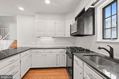 2712 Mower Street Philadelphia, PA 19152 - Photo 23 of 27 a kitchen with granite countertop white cabinets white stainless steel appliances and a sink