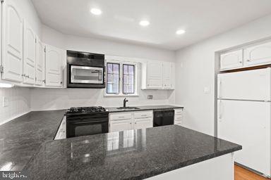 2712 Mower Street Philadelphia, PA 19152 - Photo 5 of 27 a kitchen with stainless steel appliances granite countertop a stove a refrigerator a sink a microwave and white cabinets